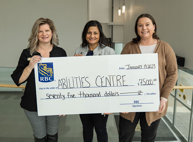 Lisa Kelly, RBC’s Community Manager for Whitby Port Perry Market hands a cheque to Pinder DaSilva, Vice President of Programs, Partnerships and Impact and Kelsey Ford, Manager, Skills Development. 