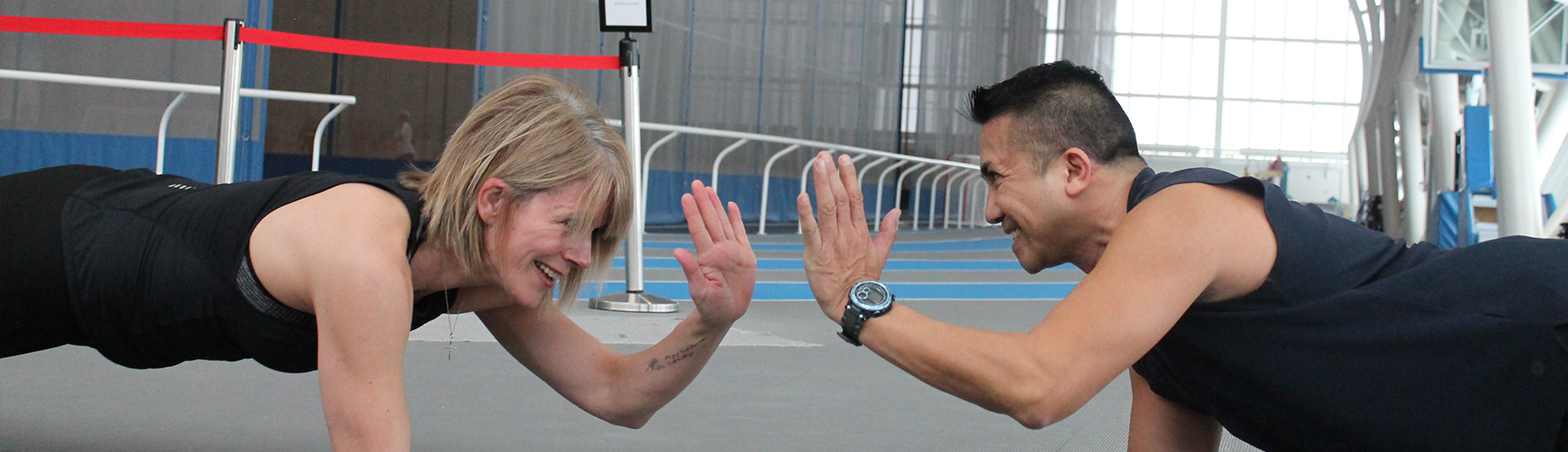 A trainer sending a high five to a member on court 