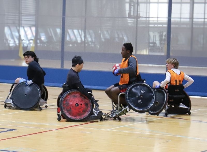 People playing wheelchair rugby.