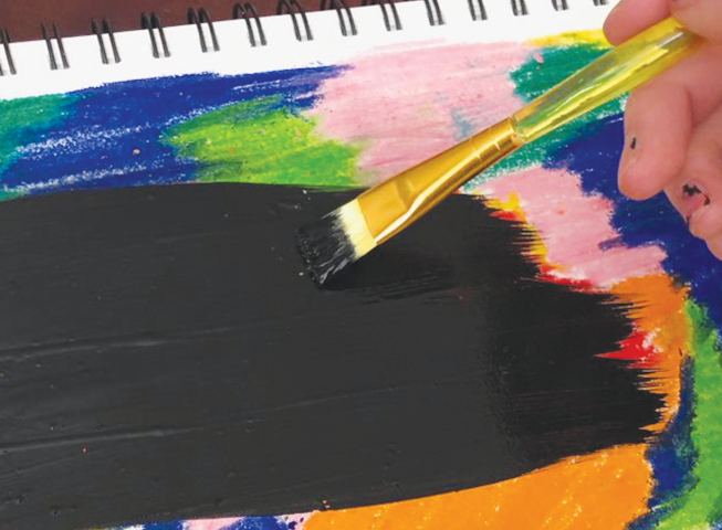 Black paint getting brushed over home made scratch art image