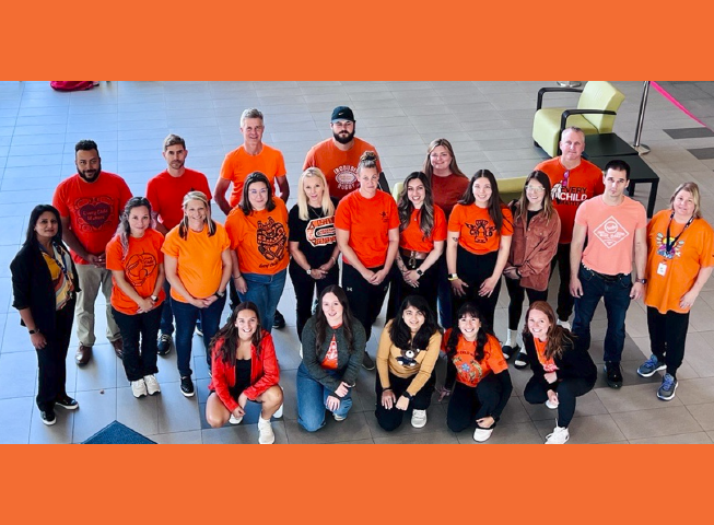 Abilities Centre Staff gather in their orange shirts.