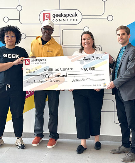 Abilities Centre Staff and Geekspeak donors hold a check 