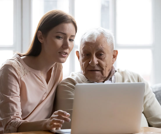 two people sit in front of a computer 