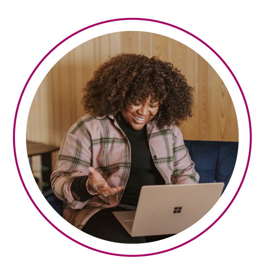 a woman sits in her living room on her laptop