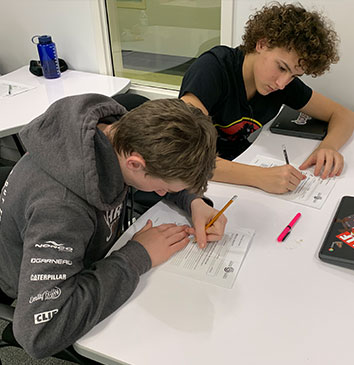 Two ASAD Students sitting at their desk studying