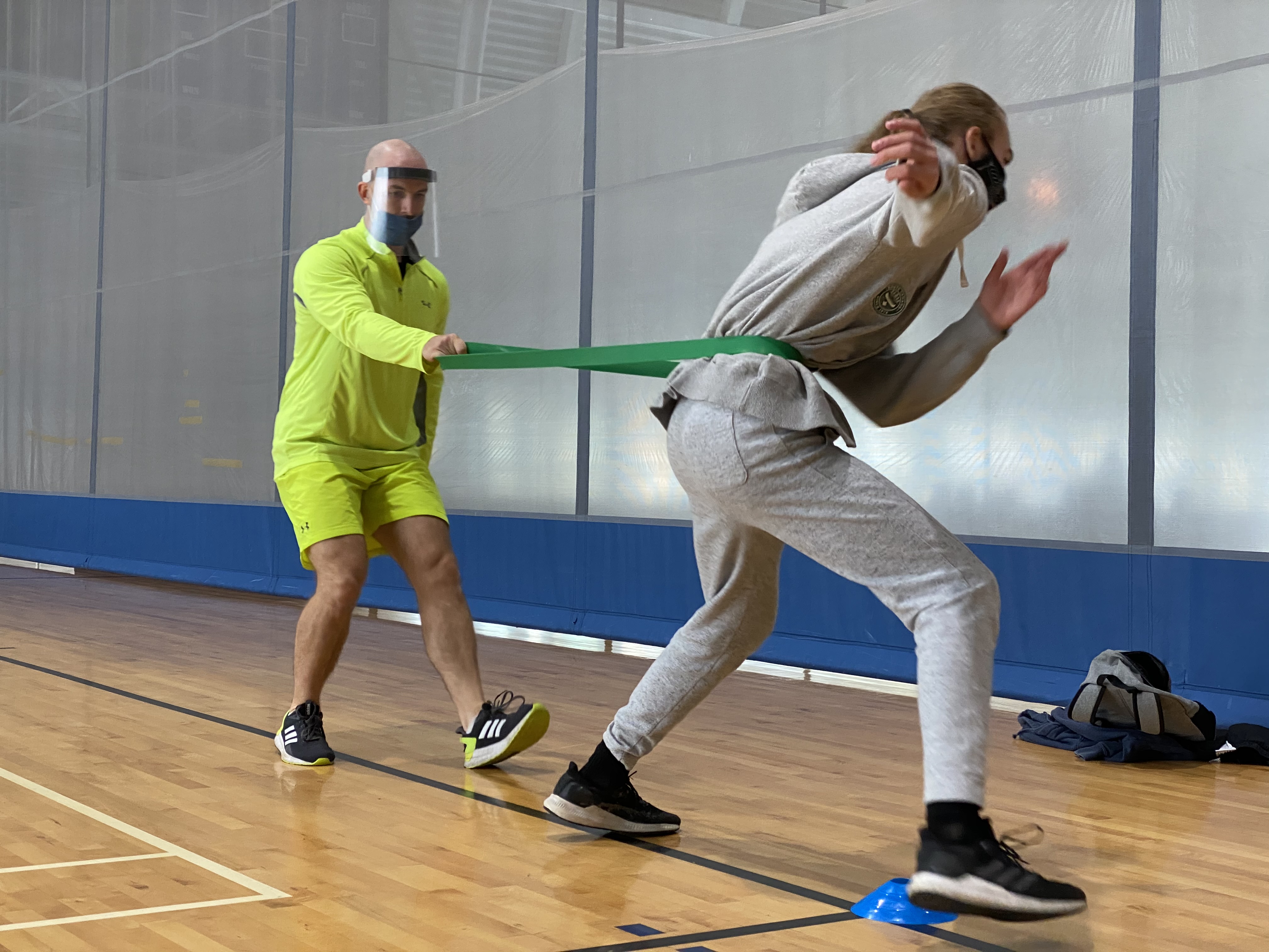 two athletes using resistant bands lunging