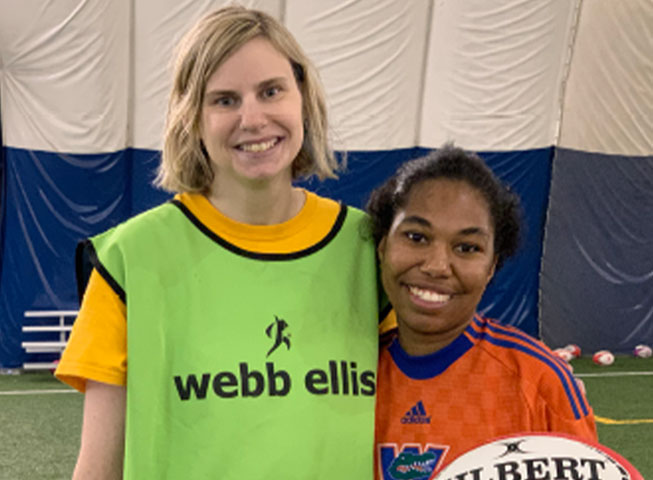 Two female participants pose holding a rugby ball during a Mixed Ability Rugby Game 