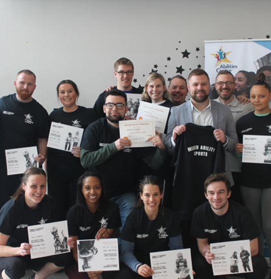 Mixed Ability Sport Coaches smile and hold their certifications