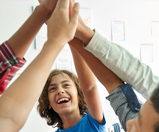 Youth ages 11-13 high five in a huddle