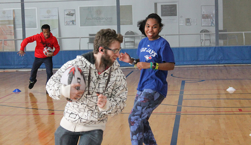 Three Thrive participants engage in active game of rugby on court floor