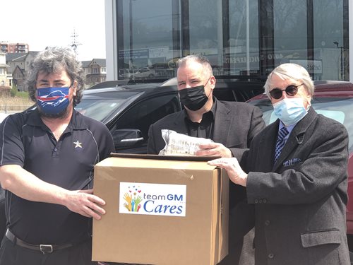 3 individuals from Gus Brown Buick GMC and Abilities Centre hold a box filled with donated masks