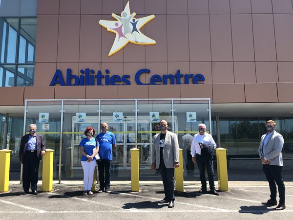 In front of Abilities Centre from left to right, MPP Lorne Coe, Sarah and Massimo Cucchiella, MPP Rudy Cuzzetto, Board Chair Mark Wafer, President and CEO of Abilities Centre Stu McReynolds