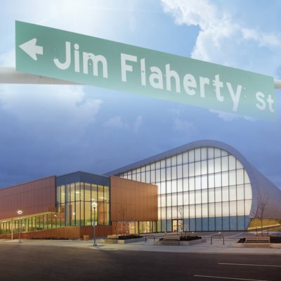 A street sign in the sky reads Jim Flaherty Street. Abilities Centre building sits below. Lower text reads “Abilities Centre. 1 Jim Flaherty Street. Whitby, Ontario