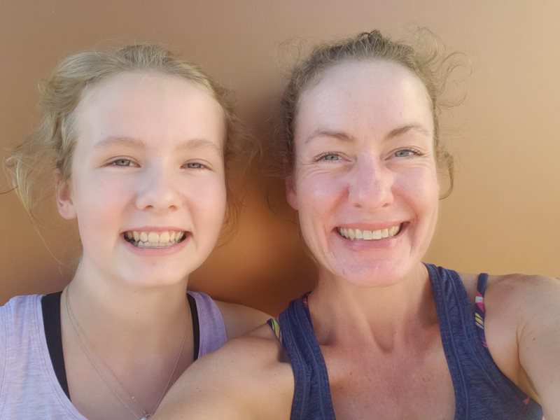 Two women, a daughter on the left and her mother Michelle on the right smile at the camera and take a selfie