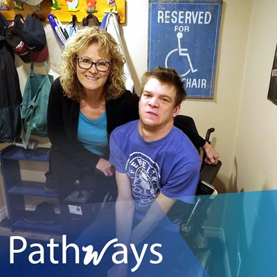 Derrick and his mom Nell smile indoors. Pathways logo is written below 