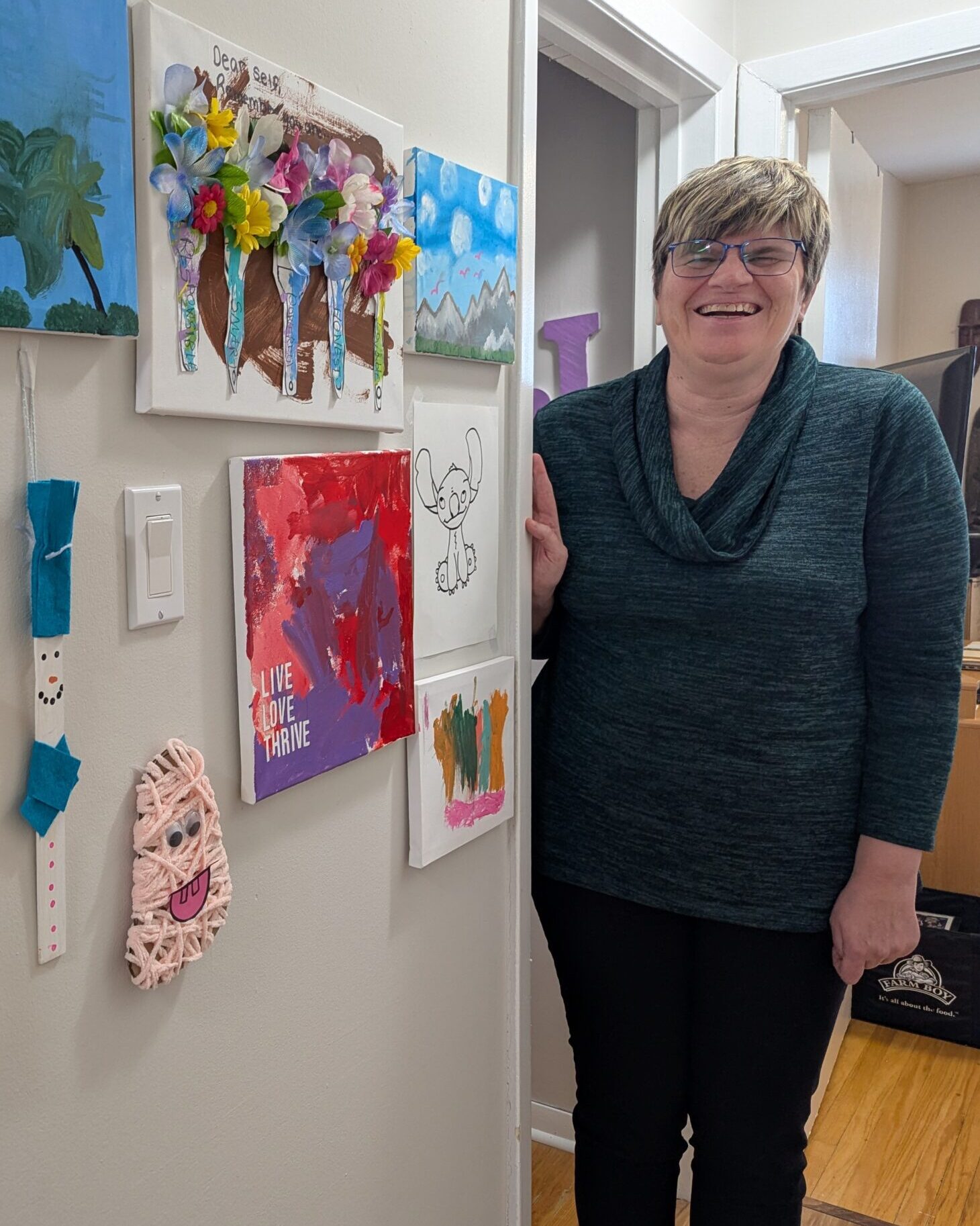 A participant beams with pride as she stands next to her artwork.