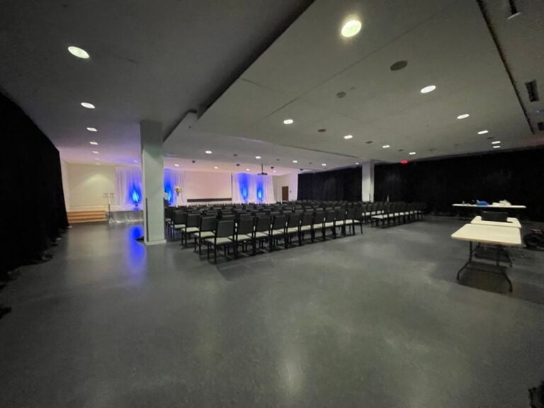 An auditorium space with a stage and rows of chairs.