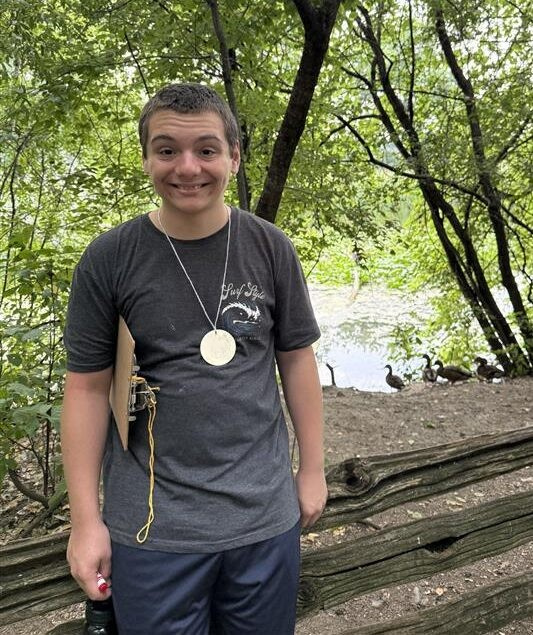 A participant smiles while standing in front of birds.