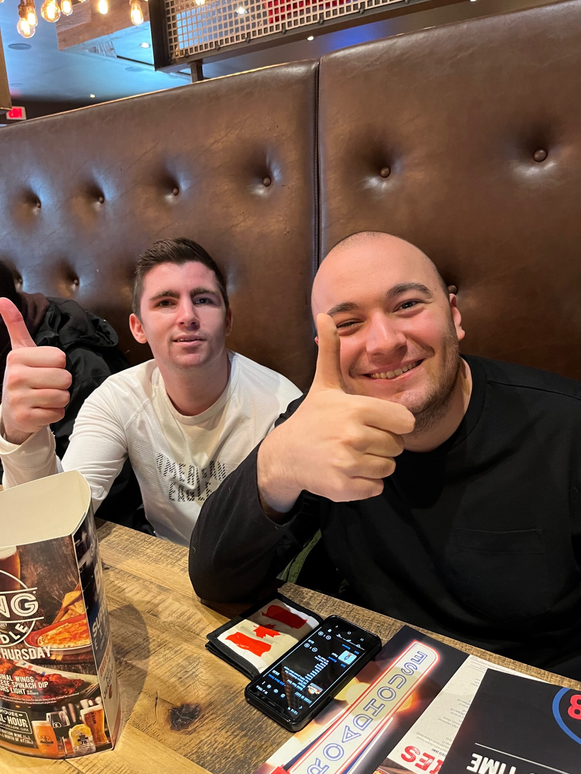 Two participants out at a restaurant giving a thumbs up.