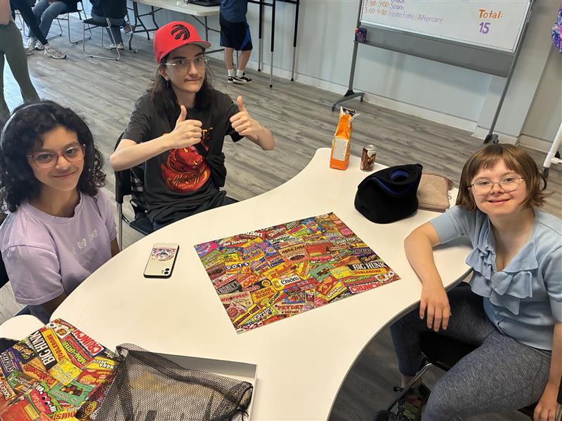 The T R I S participants sit proudly as they show off their completed puzzle.