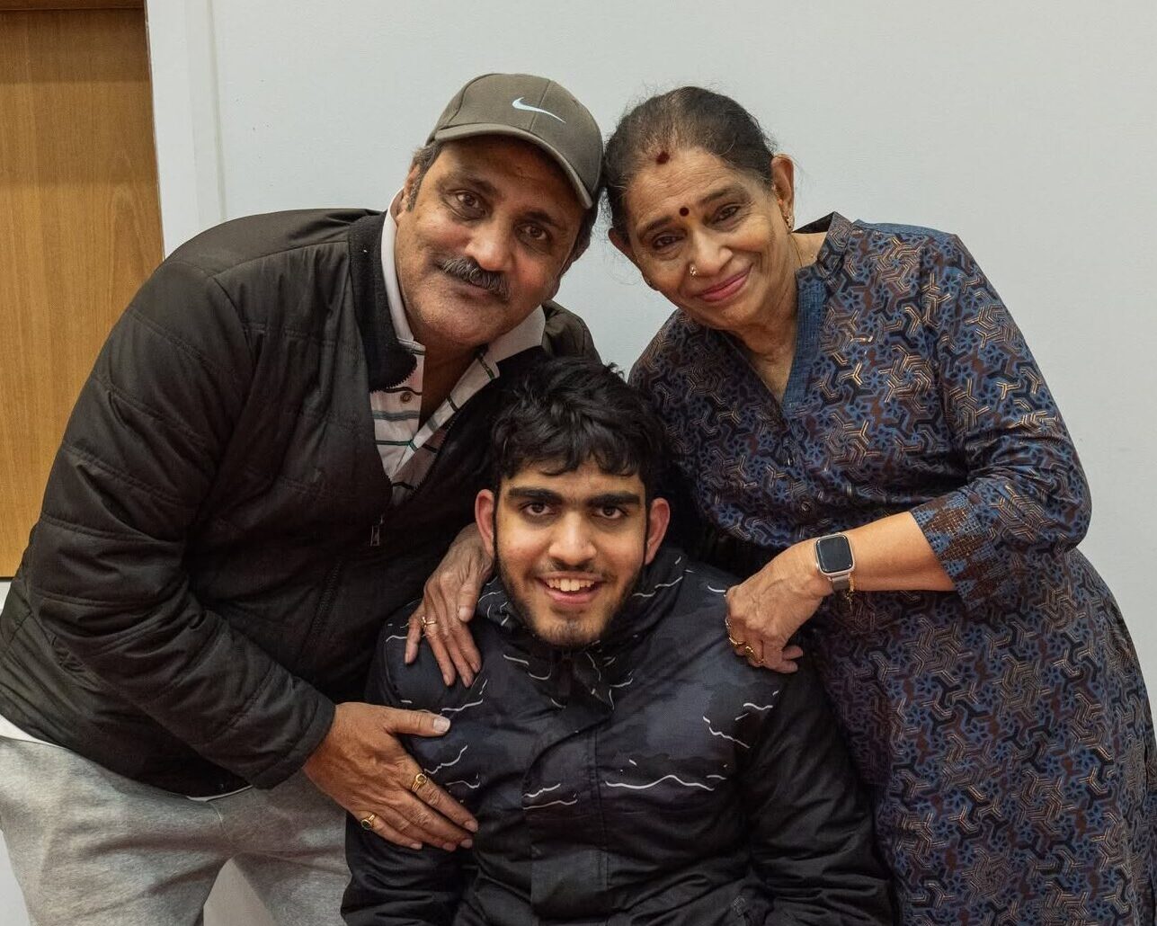 Parents pose with their son.