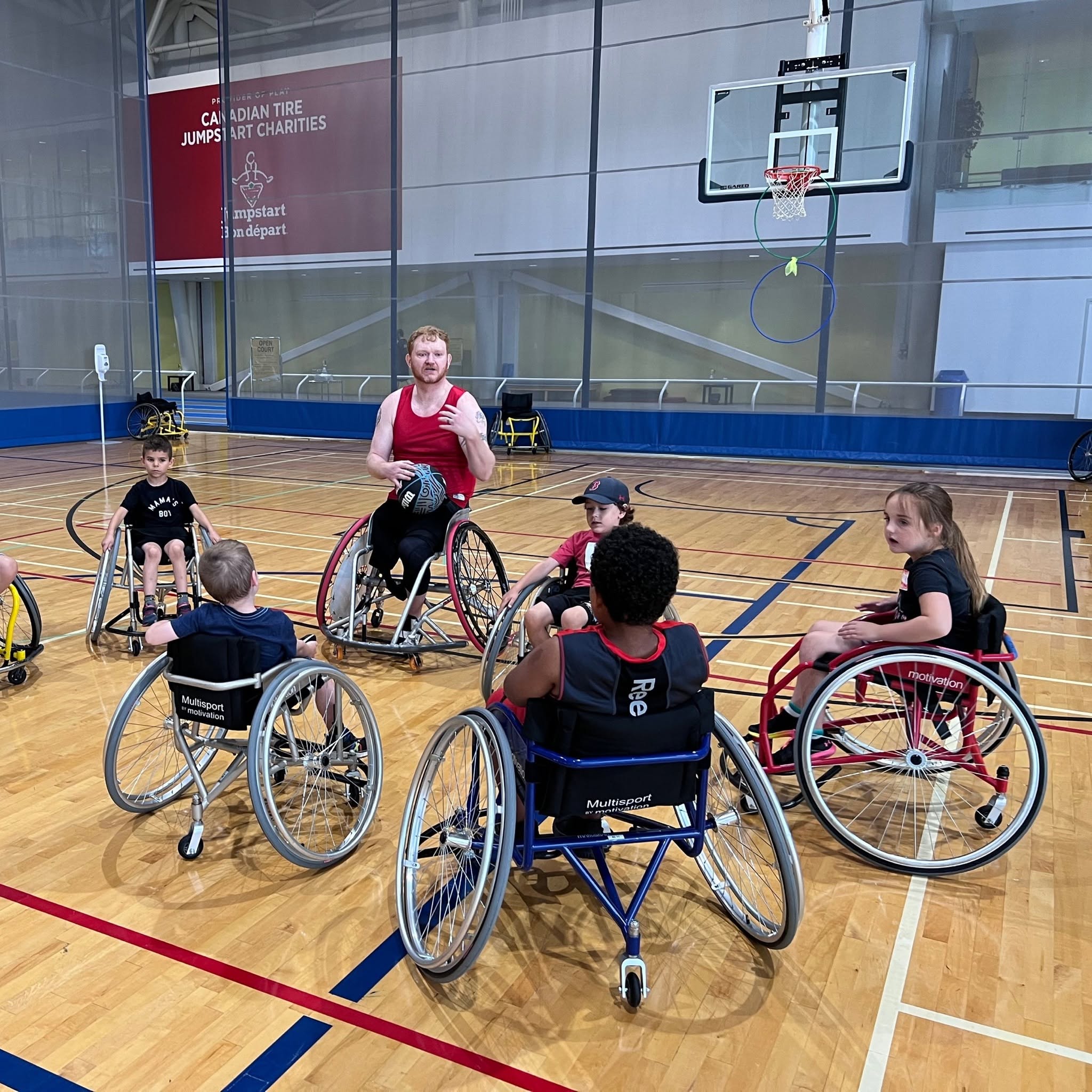 An instructor teaching kids about wheelchair basketball.