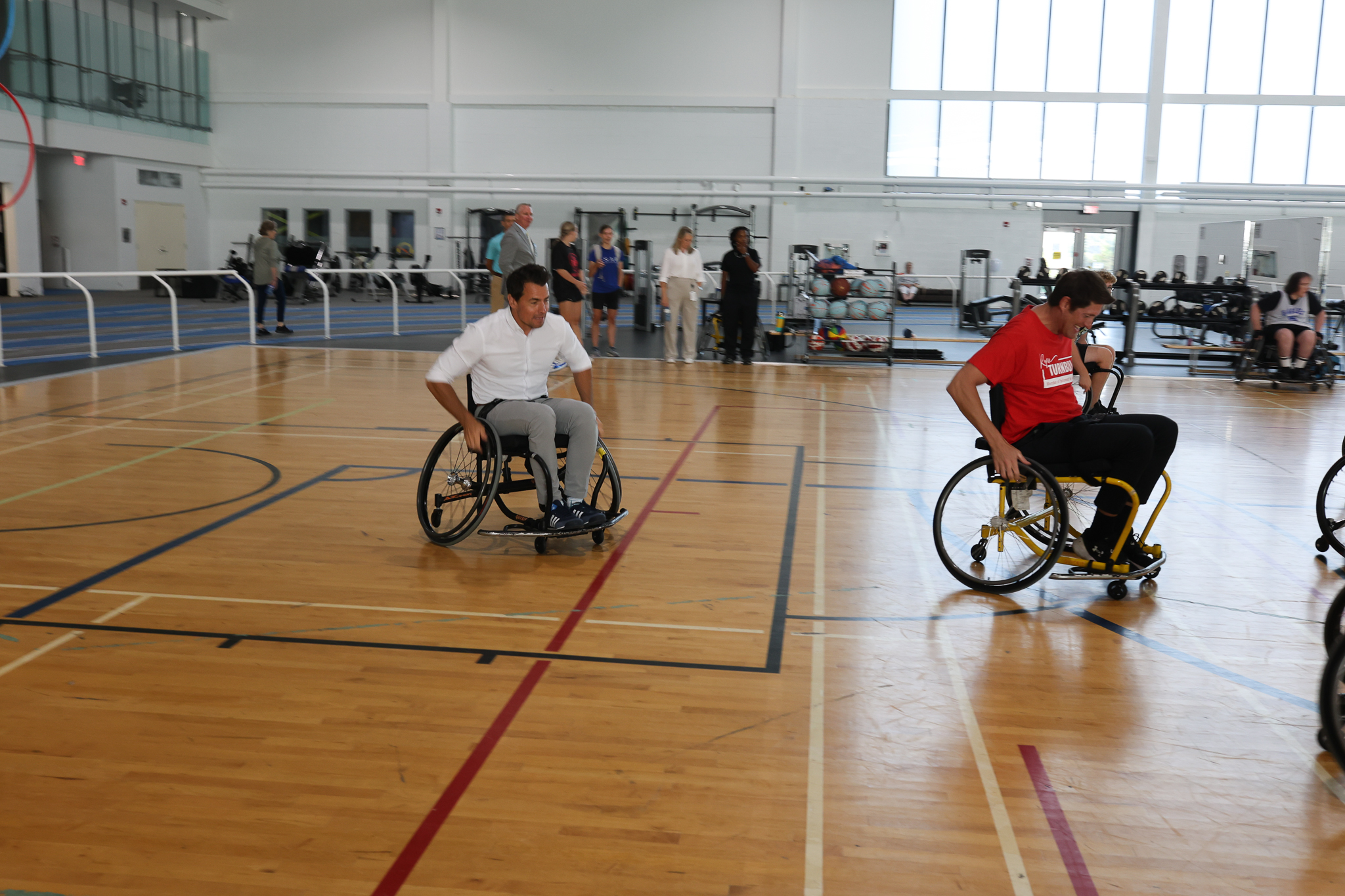 The Honourable Adam van Koeverden and M.P. Ryan Turnbull roll down the court during a game of wheelchair basketball.